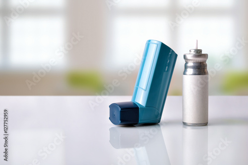 Cartridge and blue medicine inhaler in a room front view photo