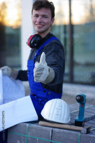 Mann mit Plänen auf der Baustelle, Planung 