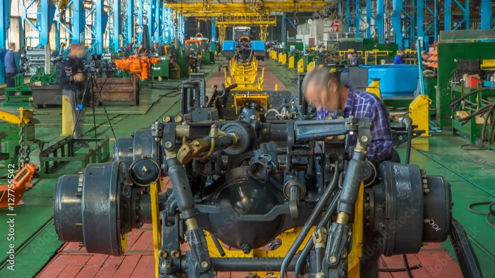 Conveyor assembly stage the body of tractor at factory timelapse