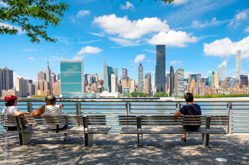 NewYorkers at a park in Queens with a view of the midtown Manhattan skyline photo