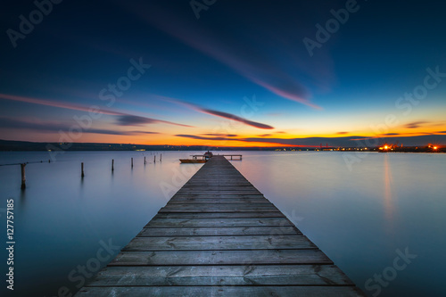Fototapeta Naklejka Na Ścianę i Meble -  Wooden Dock and fishing boat at the lake, sunset shot