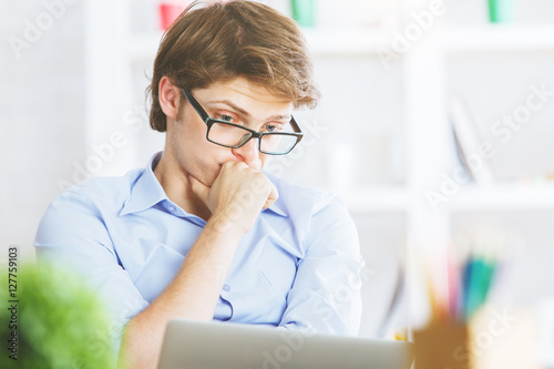 Handsome businessman looking at laptop screen