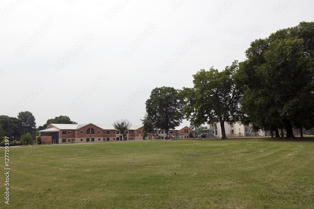Newly mowed field with elementary school in background. Horizontal. Newly mowed field with elementary school in background. Horizontal.