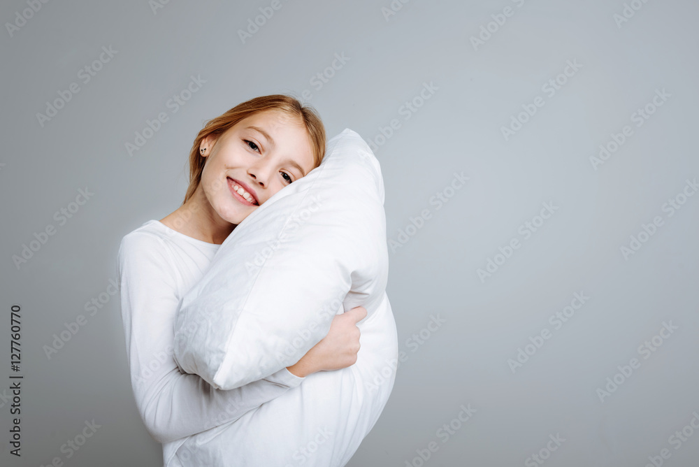 Positve cute girl holding head on the pillow Positve cute girl holding head on the pillow