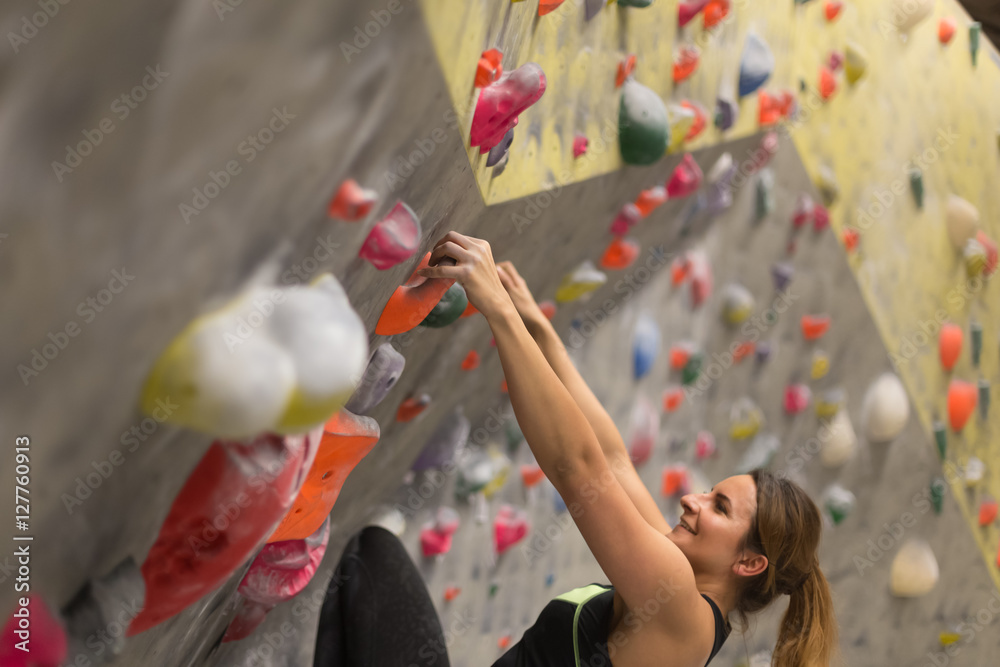 Obraz premium sporty woman in boulder climbing hall