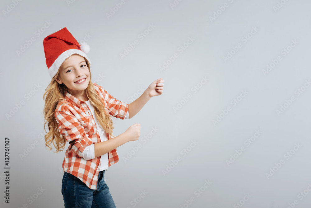 Joyful cute girl standign isolated on grey background