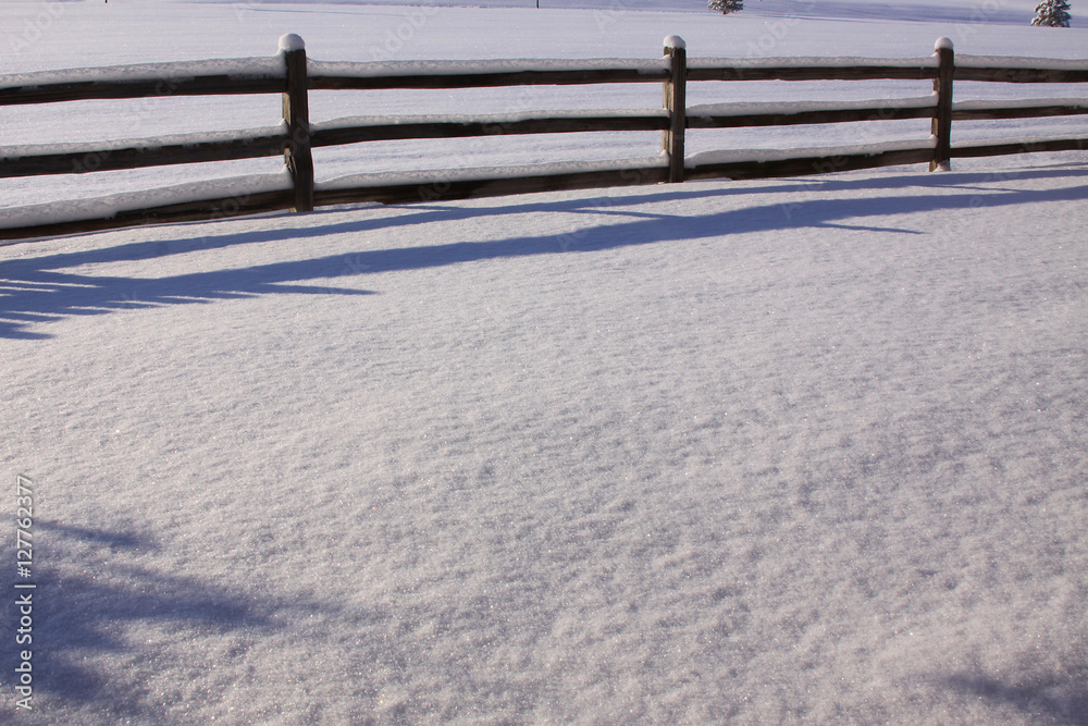 fresh snow on an old wooden fence in an open field fresh snow on an old wooden fence in an open field