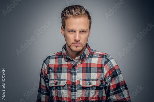 A man dressed in a red plaid shirt isolated on grey vignette bac