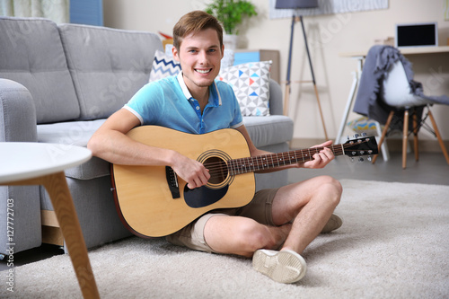Young man playing guitar in...