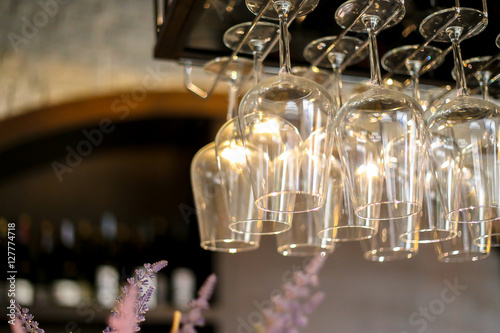 Wine's glass hanging on bar.