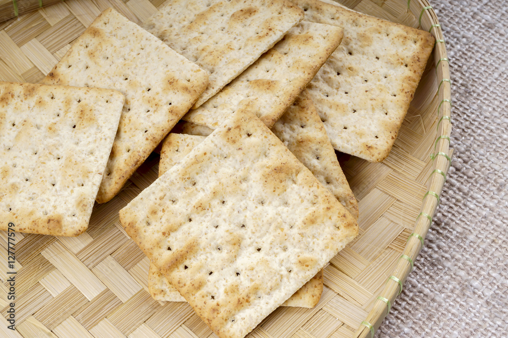 the cream cracker biscuit on the wooden background. the cream cracker biscuit on the wooden background.