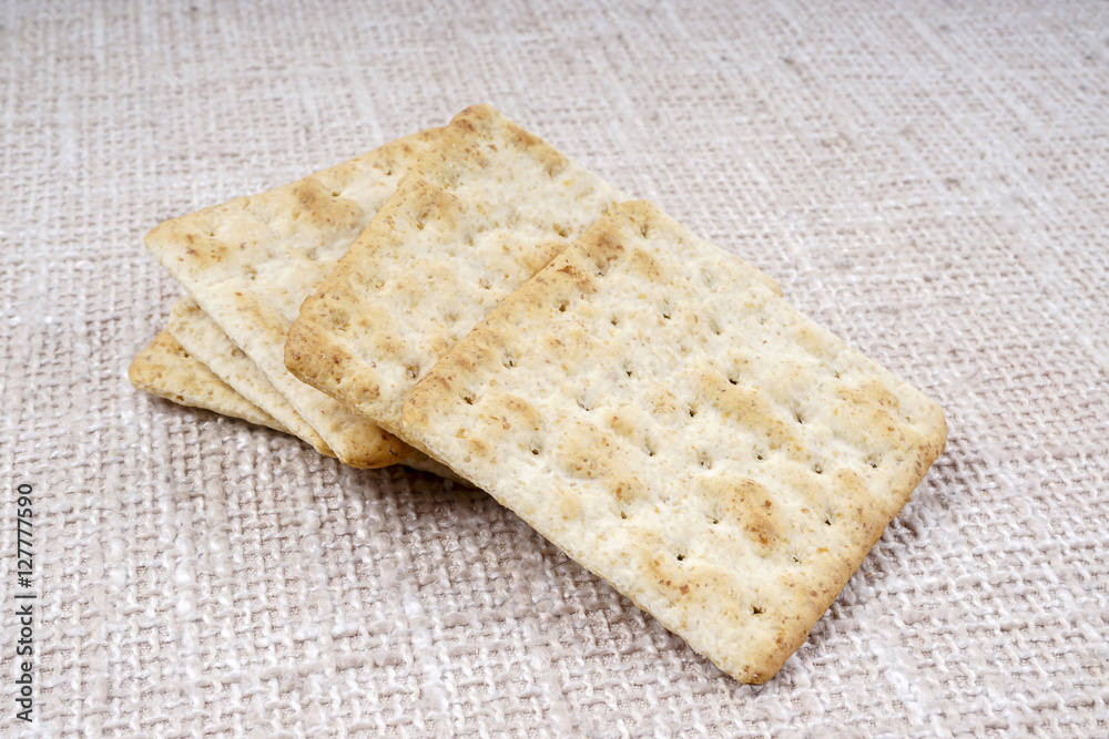 the cream cracker biscuit on the wooden background. the cream cracker biscuit on the wooden background.