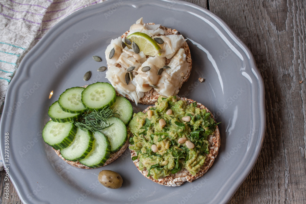 Round buckwheat or rye bread with guacamole, cucumber and fish with tahini. Love for a healthy raw food concept