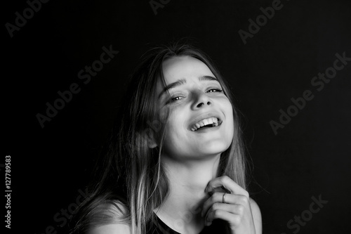 Emotional portrait of a beautiful girl with long hair. Broad good-natured happy smile