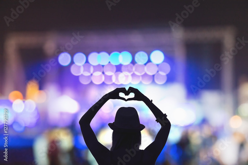 Girl making a heart-shape symbol for her favorite band.