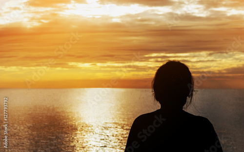 Silhouette of woman on the beach sunrise