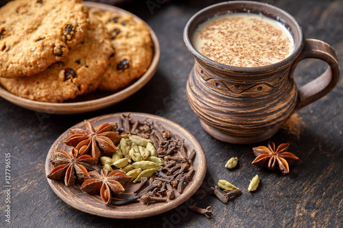 Masala pulled tea chai latte traditional hot Indian sweet milk spiced drink, ginger, nutmeg fresh spices blend, anise organic infusion healthy wellness beverage teatime ceremony in rustic clay cup