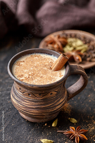 Milk tea chai latte traditional refreshing morning breakfast organic healthy hot beverage drink with natural aroma spices blend, cardamon, anise, cinnamon, in rustic ceramic cup on