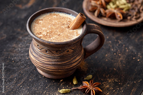 Masala pulled tea chai latte homemade hot Indian sweet milk spiced drink, ginger, fresh spices and herbs blend, anise organic infusion healthy wellness beverage teatime ceremony in rustic clay cup