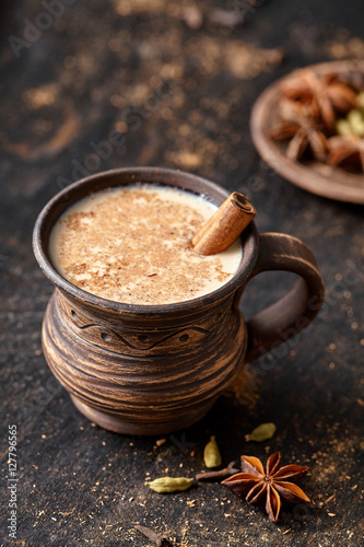 Masala pulled tea chai latte tasty hot Indian sweet milk spiced drink, ginger, fresh spices and herbs blend, anise organic infusion healthy wellness beverage teatime ceremony in rustic clay cup