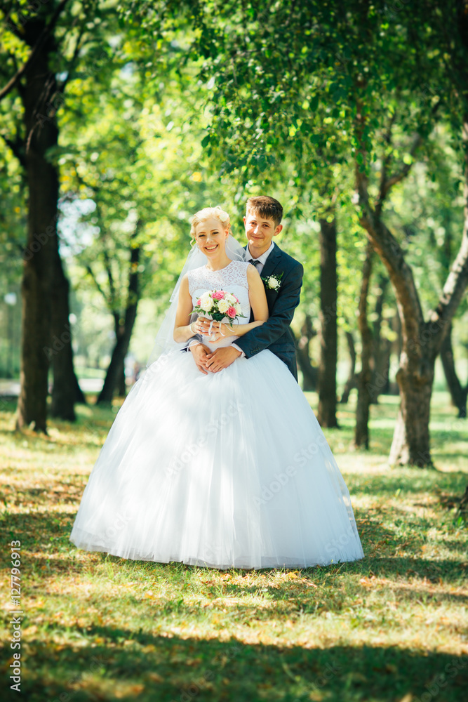 the bride and groom on the background of the park alley