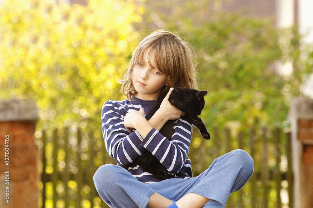 Boy Sitting Holding a Pet Kitten