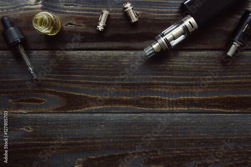 Vaping set with copy space on the wooden background.