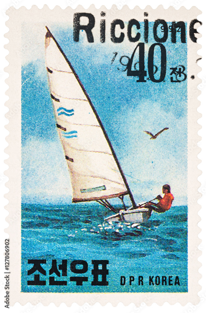Fototapeta premium Sailing yacht in the sea on postage stamp