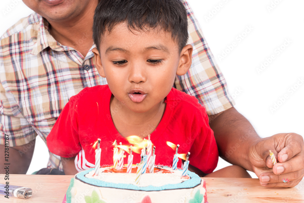 Cute little child boy with his father blowing birthday cake Cute little child boy with his father blowing birthday cake
