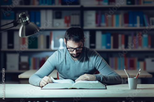 Smart man studying at night photo