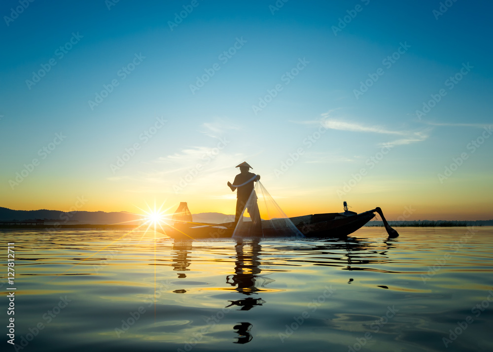Φωτογραφία Silhouette of asian fisherman on wooden boat ,fisherman in action throwing a net for catching freshwater fish in nature river, traditional fishermen at the sunset near Galle in Sri Lanka