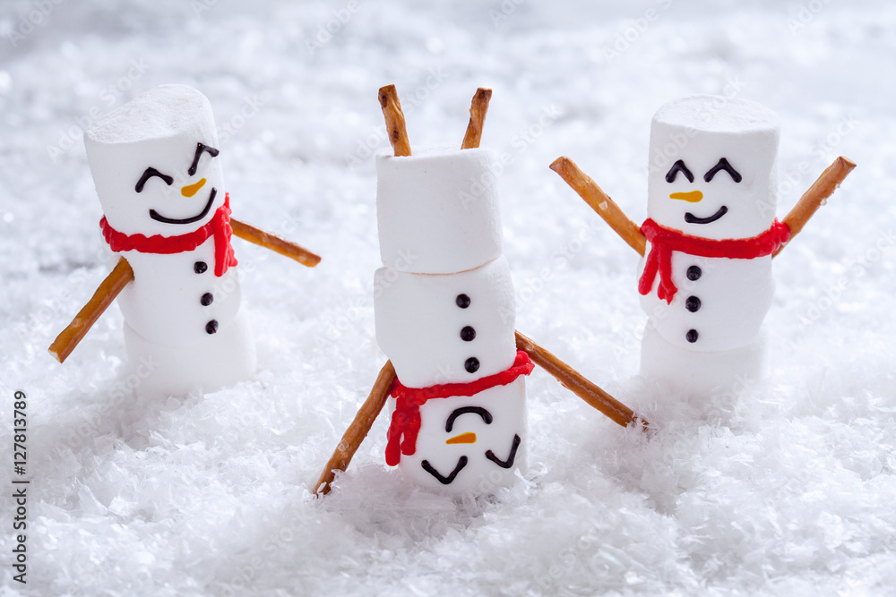 Fototapeta Szczęśliwe śmieszne bałwanki z pianki marshmallow na śniegu
