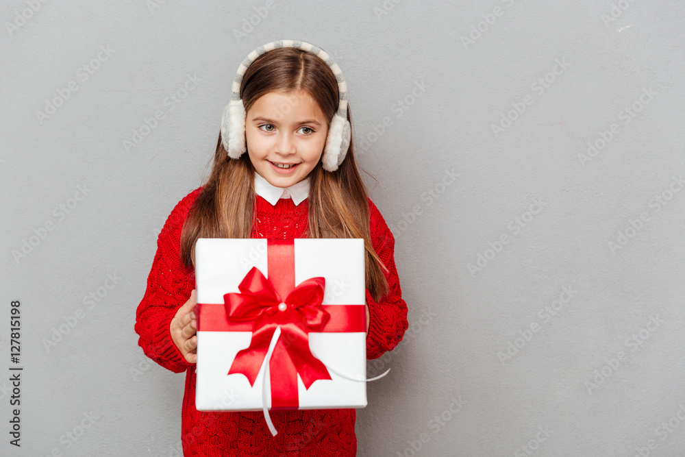 Cheerul girl in red sweater and earmuffs with gift box Cheerul girl in red sweater and earmuffs with gift box