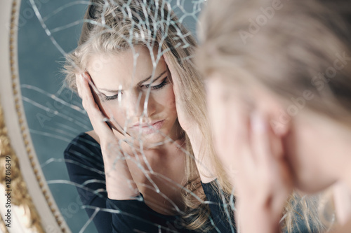 Girl reflected in broken mirror