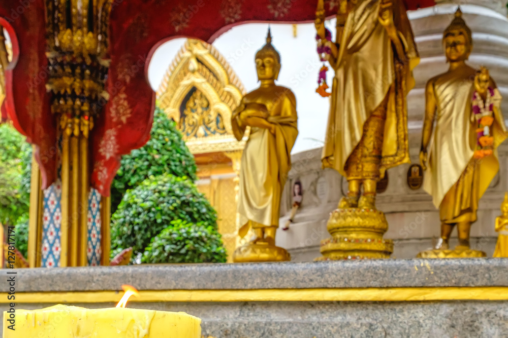 Decoration and Gold Buddha Statue in Buddhist temple Wat Chana Songkhram. It is located near popular street Khaosan road and district for tourists. Selective focus on candle