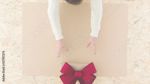 Video with woman putting on table christmas gift with ribbon