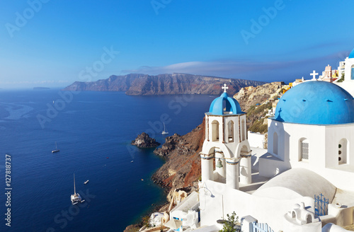 Greece. Santorini Island. The small town Oia. The Orthodox Church with the traditional blue domes and white plastered walls on the steep bank of Aegean Sea