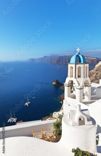 Greece. Santorini Island. The bell tower of the Orthodox Church with the traditional blue dome and white plastered walls in the town of Oia