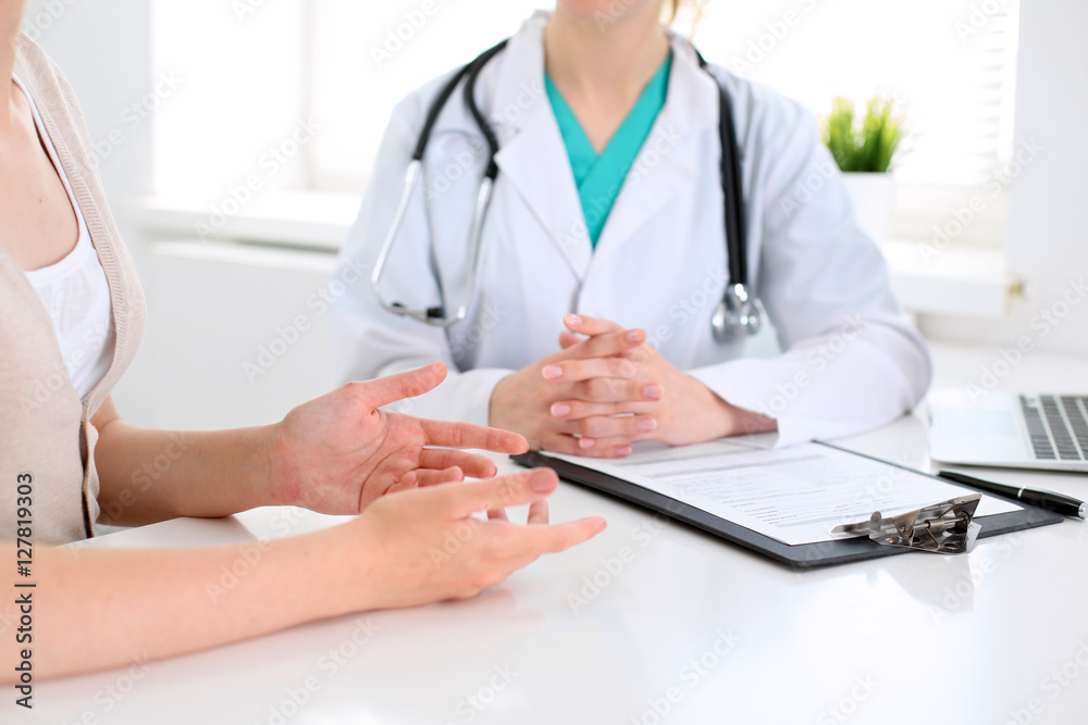 Doctor and patient are discussing something, just hands at the table Doctor and patient are discussing something, just hands at the table