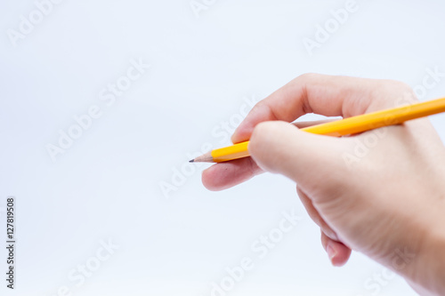 Hand with pencil writing something isolated on white background