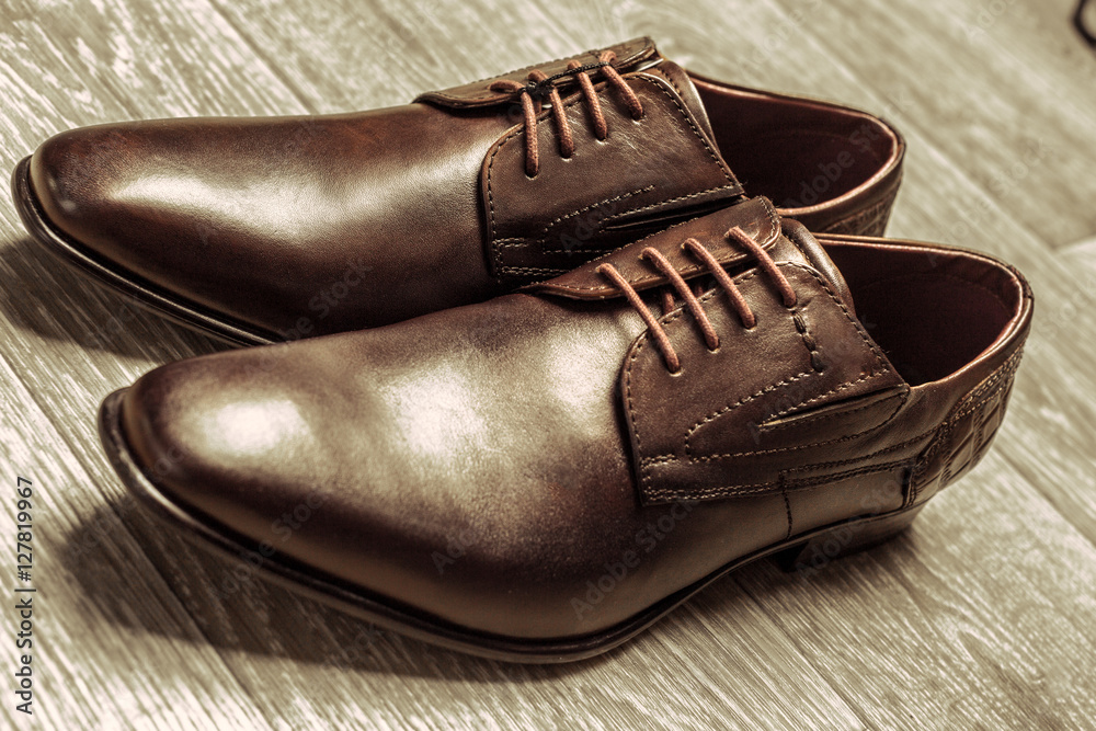 Fashion concept with male shoes on wooden background Fashion concept with male shoes on wooden background