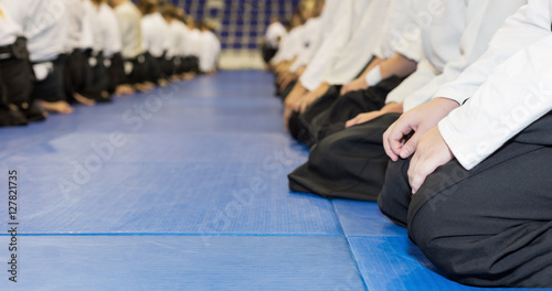 People in kimono and hakama sitting on tatami on martial arts training. Selective focus
