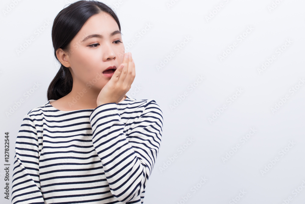 Woman checking her breath by her hand Woman checking her breath by her hand