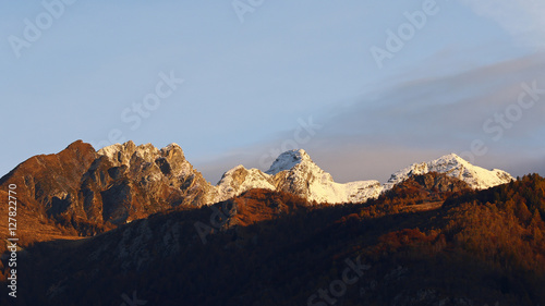Mountain landscape with forest in the fall and early snow on peaks