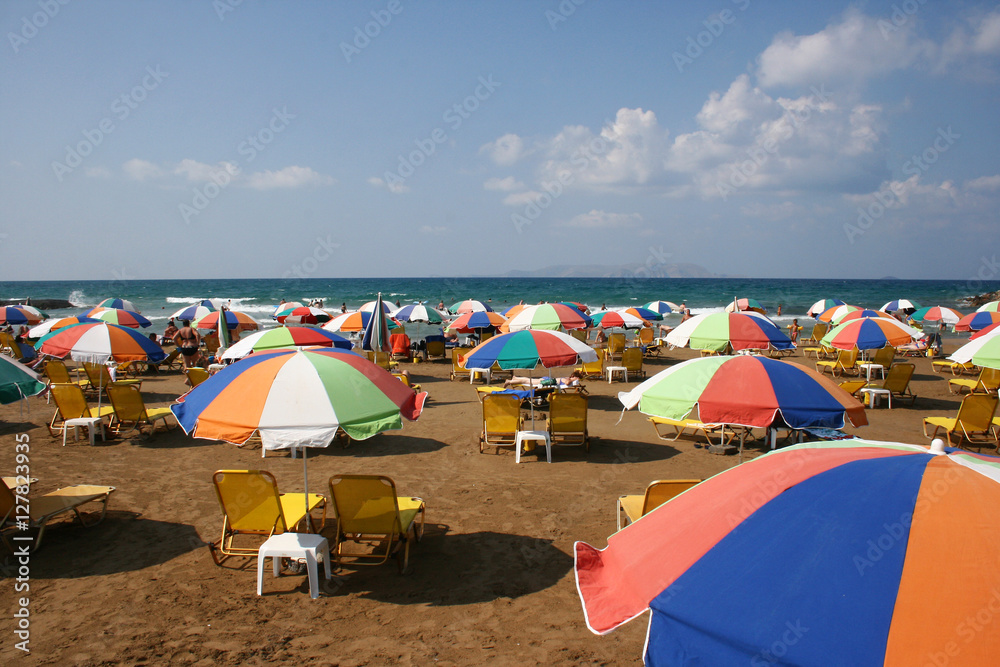 Parasols and sunbeds on a crowded beach in Crete Parasols and sunbeds on a crowded beach in Crete
