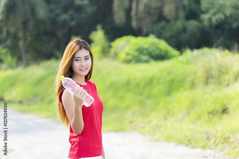 Beautiful sporty girl stops workout, relaxing drinking a water, holding a plastic bottle, outdoor workout, exercising Beautiful sporty girl stops workout, relaxing drinking a water, holding a plastic bottle, outdoor workout, exercising
