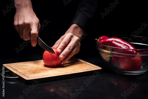 Close up of mans hands chopping tomato photo