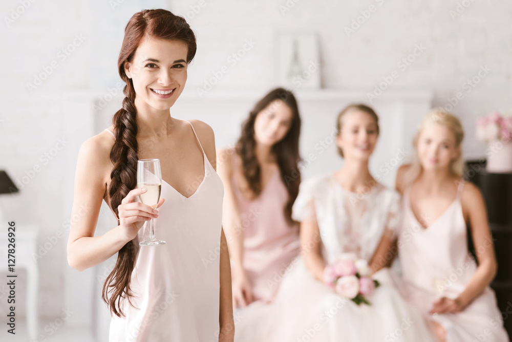 Smiling bridesmaid holding the glass of champagne Smiling bridesmaid holding the glass of champagne