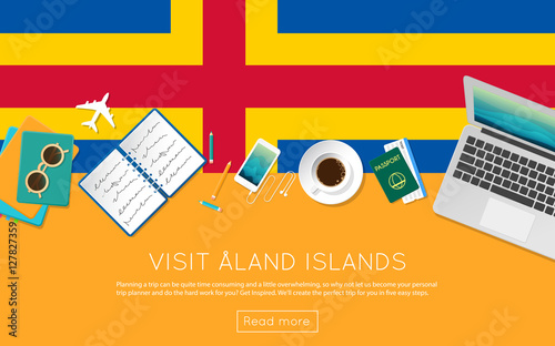 Visit Aland Islands concept for your web banner or print materials. Top view of a laptop, sunglasses and coffee cup on Aland Islands national flag. Flat style travel planninng website header.