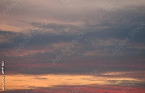 Orange, red, grey sky with clouds at sunset © cobracz